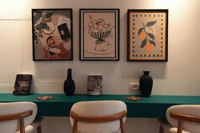 a green table with four chairs and pictures on the wall at Serene 1BR Haven Kamaran in Hurghada