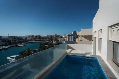 a swimming pool on the roof of a building with a view of the water at Fanadir Marina Plunge Pool & Sea View in Hurghada