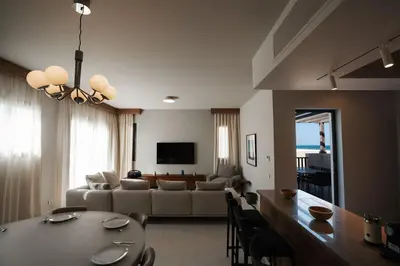 a living room with a couch and a table with chairs at Fanadir Marina Plunge Pool & Sea View in Hurghada