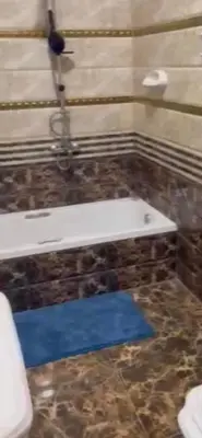 a bathroom with a white sink and a blue rug at Poseidon Apartments in Hurghada