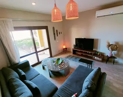 a living room with a couch and a tv at Cozy Lagoon Escpae-1Bdr Retreat in Hurghada