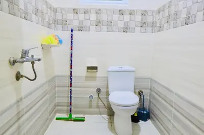 a bathroom with a toilet with a mop in it at Memnon House in Al Karnak