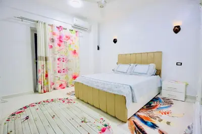 a bedroom with a bed and a rug at Memnon House in Al Karnak