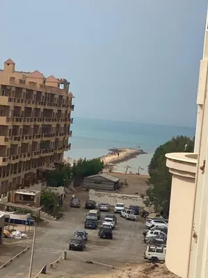a parking lot next to a beach with a building at Private apartment in Hurghada