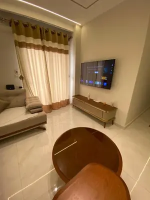 a living room with a couch and a table and a tv at Private apartment in Hurghada