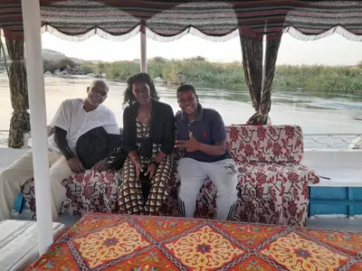 a group of three people sitting on a boat at Habob Nubian Guest House in Aswan