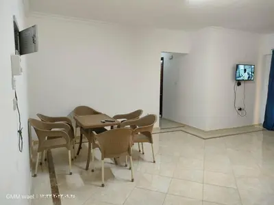 a dining room with a table and chairs and a tv at مدينة ناصر غرب أسيوط