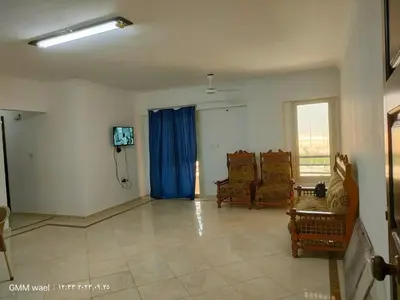 a living room with two chairs and a tv at مدينة ناصر غرب أسيوط