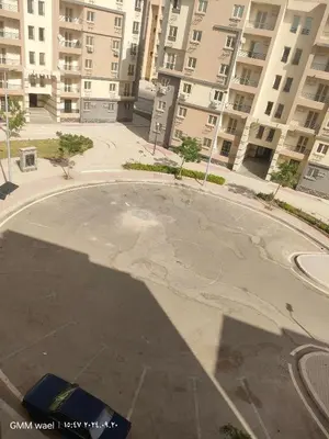 an empty parking lot in a city with tall buildings at مدينة ناصر غرب أسيوط