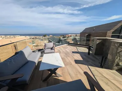 a balcony with a couch and chairs on a roof at Modern 2BR Somabay Seaview Villa Free Beach & Pool in Hurghada