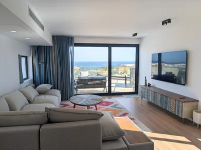 a living room with a couch and a large window at Modern 2BR Somabay Seaview Villa Free Beach & Pool in Hurghada