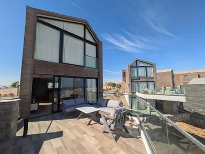 a house with a balcony with a couch and a table at Modern 2BR Somabay Seaview Villa Free Beach & Pool in Hurghada