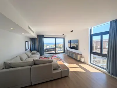 a living room with a couch and large windows at Modern 2BR Somabay Seaview Villa Free Beach & Pool in Hurghada