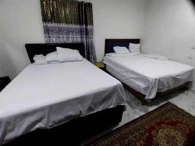 two beds in a room with white sheets at فيلا مبارك الغردقه البحر الاحمر in Hurghada