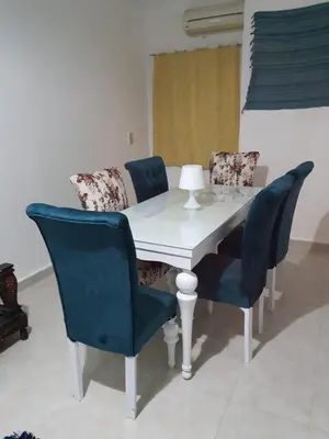 a dining room table with blue chairs and a white table at Oasis compound in Hurghada