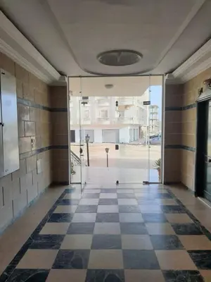 an empty hallway with a checkered floor in a building at Oasis compound in Hurghada