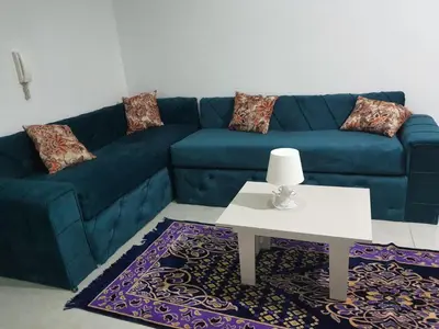 a living room with a blue couch and a table at Oasis compound in Hurghada