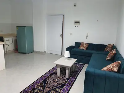 a living room with a blue couch and a table at Oasis compound in Hurghada