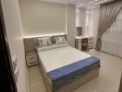 a small bedroom with a bed and a desk at Helal Apartment in Hurghada
