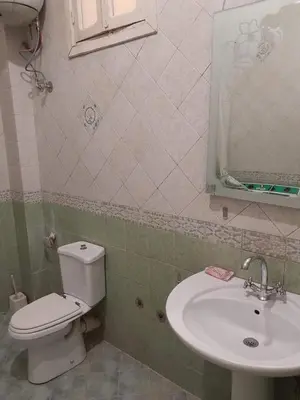a bathroom with a white toilet and a sink at Nube's dream house in Luxor