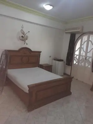 a bedroom with a wooden bed and a window at Nube's dream house in Luxor
