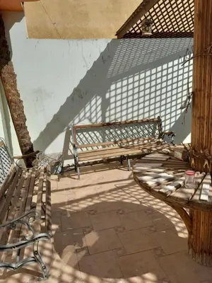 two wooden benches sitting on a patio at Nube's dream house in Luxor
