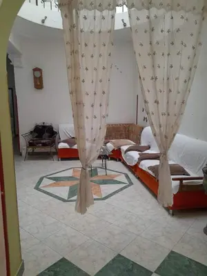 a bedroom with two beds and curtains in a room at Nube's dream house in Luxor