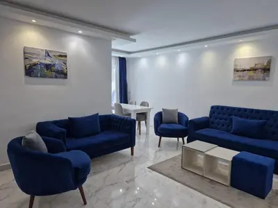 a living room with blue couches and a table at Hurghada Fanader Bay Lever111 in Hurghada