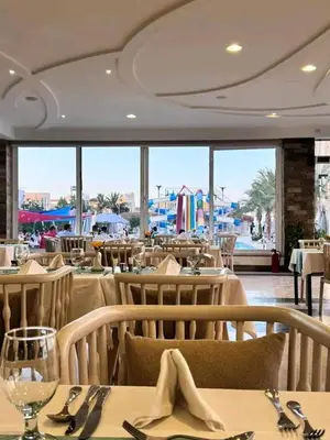 a restaurant with tables and chairs with a view of the ocean at Hurghada Fanader Bay Lever111 in Hurghada