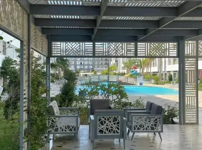 a patio with two chairs and a swimming pool at Hurghada Fanader Bay Lever111 in Hurghada