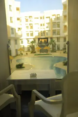 a table and chairs with a view of a building at One bedroom apartment with living room in Aqua Infinity before El Gouna in Hurghada