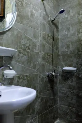 a bathroom with a shower with a sink and a mirror at One bedroom apartment with living room in Aqua Infinity before El Gouna in Hurghada