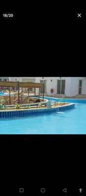 a large swimming pool with blue water in a building at One bedroom apartment with living room in Aqua Infinity before El Gouna in Hurghada