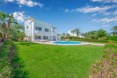 a white house with a yard and a swimming pool at Beautiful 4 BDR Villa With Private Pool in Hurghada