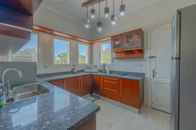 a large kitchen with wooden cabinets and a sink at Beautiful 4 BDR Villa With Private Pool in Hurghada