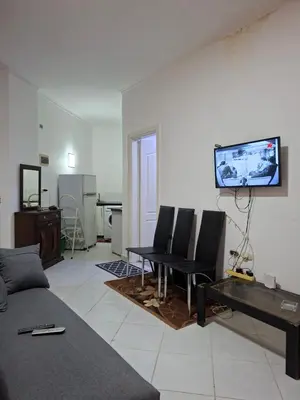 a living room with a couch and a tv on the wall at Desert pearl in Hurghada