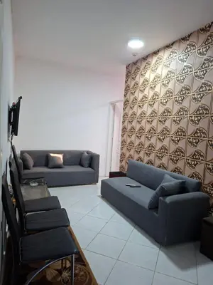 a living room with two blue couches and a wall at Desert pearl in Hurghada