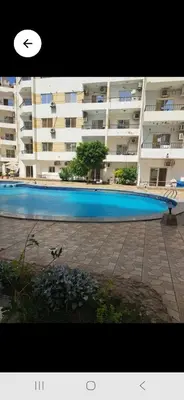 a large swimming pool in front of a large building at Lotos studio in Hurghada
