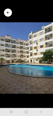 a large apartment building with a large swimming pool at Lotos studio in Hurghada