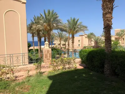 a view of a resort with palm trees and a pool at Sunset Pearl Sahl Hashesh in Hurghada