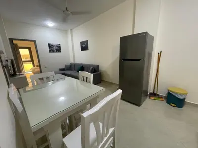a living room with a table and a refrigerator at Bayt Hassan A13 - Superb 2 bedrooms in Hurghada