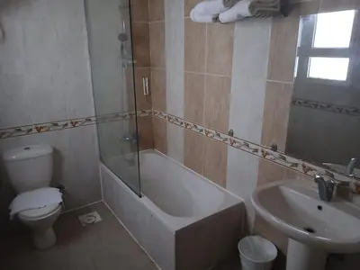a bathroom with a tub and a toilet and a sink at Soleya Residence in Hurghada