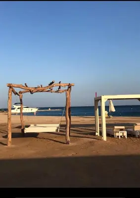a beach with a swing and an umbrella on the beach at Princess Resort in Hurghada