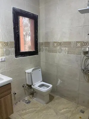 a bathroom with a toilet and a sink and a window at شقة مبارك in Hurghada