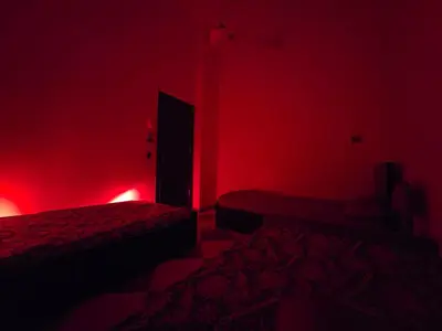 a room with two beds in a red room at Golden home in Aswan