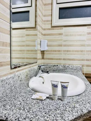 a bathroom sink with two cups on a counter at Hurghada Studios in Hurghada