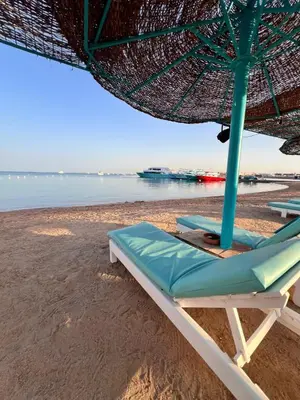 a beach chair with an umbrella on a beach at Hurghada Studios in Hurghada