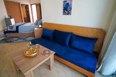 a bedroom with a blue couch and a table at Hurghada Studios in Hurghada