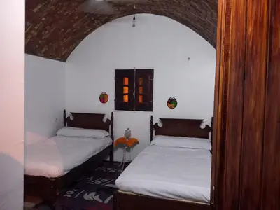two beds in a room with an archway at Soul House in Jazīrat Fīlah