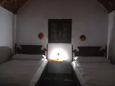 two beds in a room with a light between them at Soul House in Jazīrat Fīlah